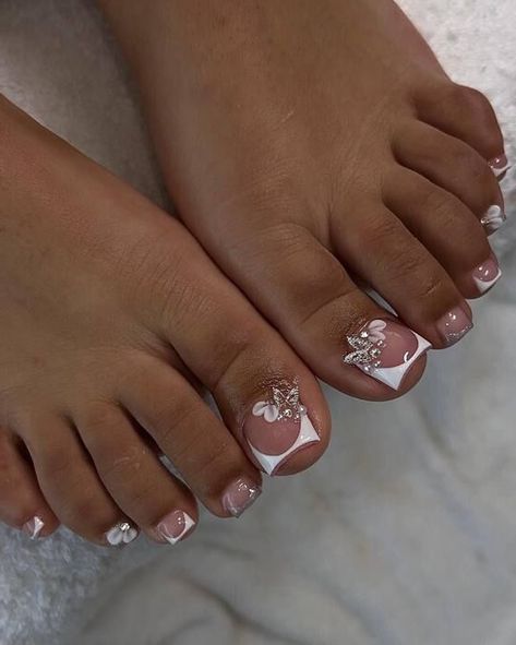 This enchanting design showcases a gentle blend of soft pinks and whites, adorned with delicate floral motifs and sparkling highlights delicately applied to the prominent toes. Its understated swirls and floral patterns lend a distinctly feminine allure, making it ideal for weddings or any noteworthy event where an elegant and poised presence is desired. Elegant Pedicure, White Toenail Designs, White Toenail, Summer Nails Colors Designs, Pedicure Designs Toenails, Toenail Designs, Pedicure Ideas, Gel Toe Nails, Acrylic Toes