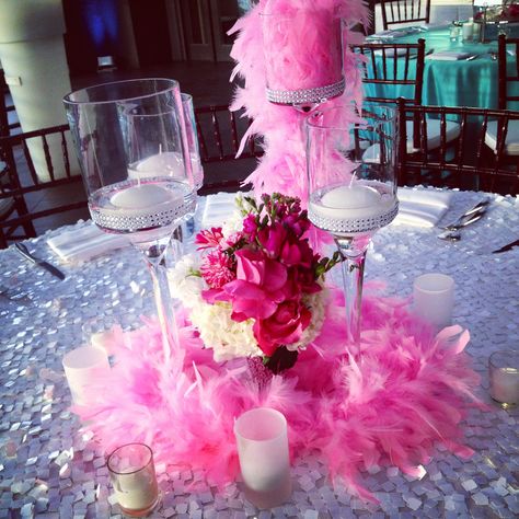 Candle holders with floating candles surround flowers in pink & white in a "bling" vase for this Bat-mitzvah birthday party. A pink feather boa cascades out if the tallest candle holder. Also frosted votive holders balance out the centerpiece. #paulfennerfloraldesign #tablecenterpiece #bat-mitzvah #candleholders #candycenterpieces Feather Boa Centerpiece, Boa Centerpiece, Pink Feather Boa, Bling Candle Holders, Pink Bat Mitzvah, Candy Centerpieces, Tall Candle Holders, 30th Bday, Daughters Day