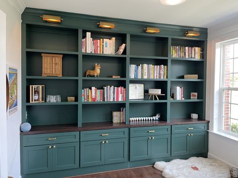 This built-in features brass light fixtures and hardware for an elegant touch. The countertop was stained in oak espresso and the built-in was painted in Benjamin Moore’s hunter green. Green might be unexpected, but it is fresh and natural and will breathe life into any space. Share:TweetWhatsApp Built In Shelves Office, Painted Built In Bookshelves, Build In Office, Green Built Ins, Butcher Block Cabinets, Brazilian Apartment, Built In Library, Green Bookshelf, Brass Light Fixtures