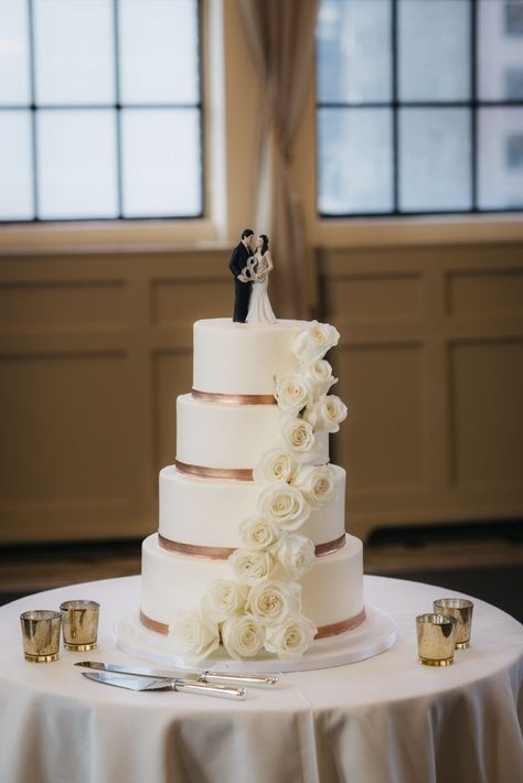 Smooth buttercream, rose gold ribbon, fresh flowers Photo Credit: erinhoytphotography Simple Wedding Cake Rose Gold, White Wedding Cake With Gold Accent, White Wedding Cake With Greenery And Gold, Champagne Colour Wedding Cake, Wedding Cake With White Flowers, Cake With White Flowers, Gold Drip Wedding Cake With Flowers, Wedding Cake Gold, Cream Wedding Cake