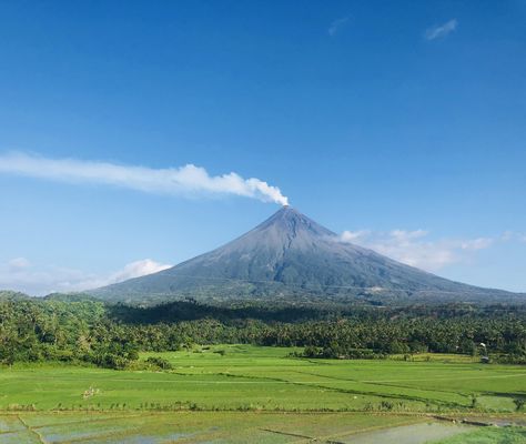 This majestic view of Mt. Mayon spewing white smoke. Mt Mayon, Volcano Pictures, Air Travel Tips, Mountain Aesthetic, Ppt Background, Pretty Nature, Class Pictures, Airport Travel, Ghost Pictures