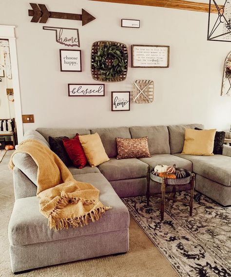 Silver metal and stained wood tray top side table used as a coffee table for gray sofa stands on a beige and black rug. Yellow, red and brown decorative pillows and a yellow throw blanket adorn the chaise lounge sofa. Beige And Red Living Room, Grey Farmhouse Living Room, Grey Leather Couch, Round Black Coffee Table, Grey Sectional Couch, Couch Designs, Tufted Ottoman Coffee Table, Light Gray Couch, Brown Decorative Pillows