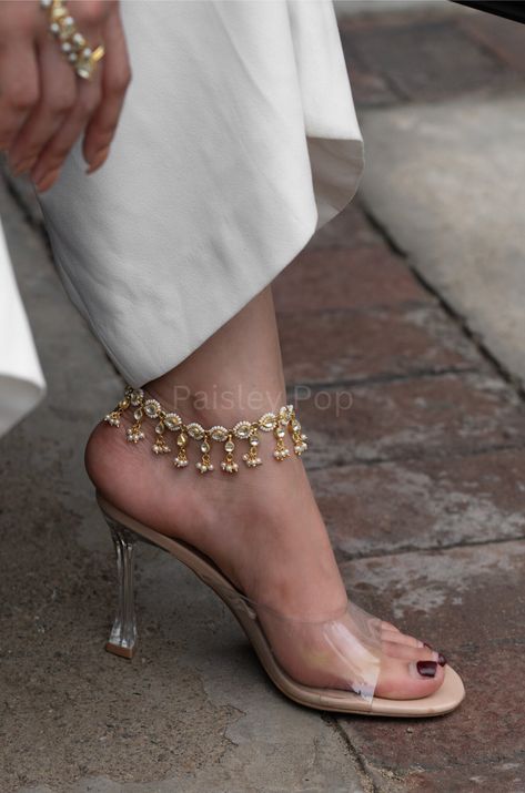 The Gold Plated Kundan anklets are an elegant and traditional piece of jewelry, featuring the classic Kundan design, highlighted with lovely pearls for an extra charm. These Handcrafted Kundan Payal anklets are classic and timeless and can be cherished for years. These Kundan and Pearl anklets are a true mastery of fine craftsmanship and intricated details. Closure - Lobster Weight- 36gm Handcrafted in Jammu and Kashmir Paisley Pop travels the depths of India to learn techniques and crafts from Kundan Anklets Design, Kundan Payal Bridal, Bridal Payal Designs, Gold Payal Design, Gold Anklets Indian, Jwellary Unique, Kundan Anklets, Gold Payal, Traditional Anklets