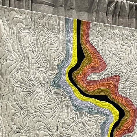 Canadian Mod Quilt Collective on Instagram: "Minimalist Design⁠ ⁠ On the Verge⁠ ⁠ By Tara Evans @taraleequiltery⁠ ⁠ Stonewall, Manitoba, Canada⁠ ⁠ This quilt started as a pencil sketch of eight cragged lines that echo off each other. The resulting shape feels organic, like a path of a river bed or a crack in the earth. I knew I wanted to create each pathway of color out of a continuous cut of fabric so that there were no seams. I enlarged my initial sketch to create templates I could use to cut my large pieces of fabric. I pieced the strips together using a combination of machine piecing and hand sewing when the curves became too tight to accurately maneuver under the machine. I quilted the negative space with a heavy black thread, echoing the cragged pathway and then eventually flattening Mod Quilt, Create Templates, Instagram Minimalist, Heat Waves, River Bed, Manitoba Canada, The Verge, Black Thread, Free Motion Quilting