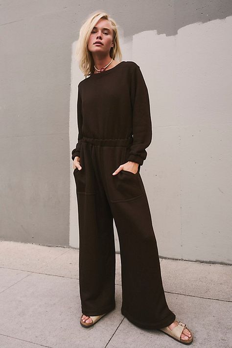 An effortless done-in-one from our free-est collection, this jumpsuit is the definition of cozy meets chic. **Fit:** Relaxed throughout with cinched waistband **Features:** Crew neckline, wide-leg silhouette, side pockets, back keyhole cutout, pull-on design **Why We ❤ It:** Throw-on-and-go with simple sneakers or elevate it with sleek sandals — this style has endless ways to wear. | Darla One-Piece by free-est at Free People in Brown, Size: S Fall Jumpsuit, Simple Sneakers, Jumpsuit Fall, Winter Jumpsuit, Comfy Jumpsuits, Boho Clothing, Boho Outfits, Crew Neckline, Free People