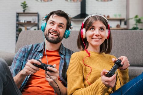 Smiling young couple with headphone on their head playing the video game Photo | Free Download Two People Playing Video Games, Someone Playing Video Games, Playing Video Game Poses Drawing, Playing Video Games Drawing Reference, Friends Playing Video Games, Commercial Cinematography, Duo Reference, Gaming Couple, Game Photo