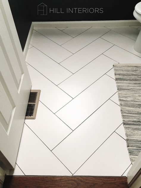 White Tile Herringbone Floor, White Herringbone Tile Black Grout, White Tile Floor Dark Grout, Large Tile Herringbone Floor, White Tile With Black Grout Floor, White Tile Dark Grout Kitchen Floor, Bathroom Floor Tile Black Grout, Powder Room Herringbone Floor, White Chevron Floor Tile