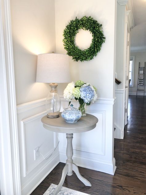 Classic styled entryway. Simple pedestal entry table with fresh flowers and a boxwood wreath for a pop of greenery Small Corner Ideas, Round Foyer Table Decor Entryway, Round Foyer Table Decor, Room Corner Decor, Small Corner Decor, Corner Decorating Ideas, Living Room Corner Decor, Corner Table Living Room, Foyer Table Decor