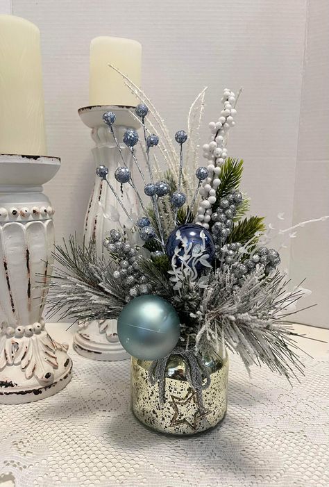 Icy blue Xmas balls with frosty white Xmas greens, Blue & silver accents in a shiny silver container. #decor #decoration #arrangement #xmasdecor #xmas #blue #silver #frosty #xmasdecor Blue And Silver Christmas Table Decor, Blue And Silver Christmas, Xmas Balls, Teal Christmas, Blue Centerpieces, Church Altar, Silver Centerpiece, Christmas Centers, Christmas Vases