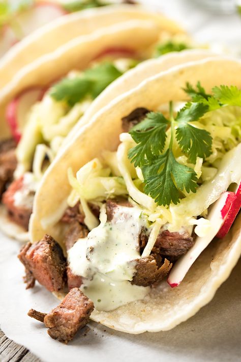 These steak tacos are deliciously juicy and zesty, topped with a citrusy slaw and mildly spicy and creamy jalapeno sauce! | thecozyapron.com #steaktacos #steaktacosrecipe #steaktacosmarinade #steaktacosrecipeseasy #steaktacoseasy Steak Taco Sauce, Steak Taco Marinade, Steak Taco Recipe, Creamy Jalapeno Sauce, Steak Taco, Stomach Rumbling, Southwest Recipes, Creamy Jalapeno, Jalapeno Sauce