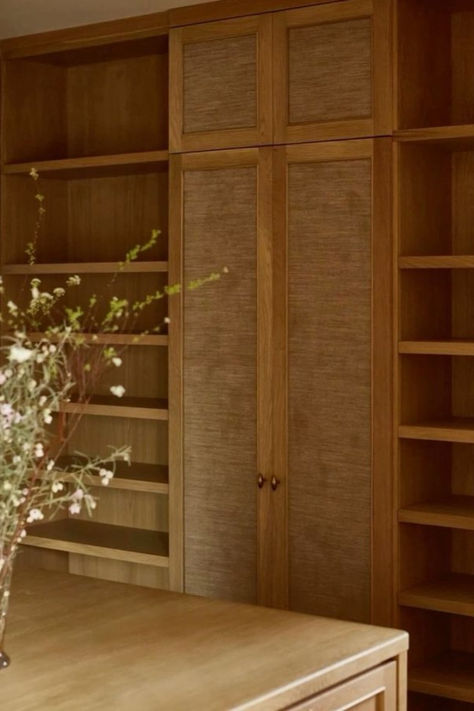 Image of elegant wooden bookshelves with built-in storage, showcasing a natural wood finish and minimalistic design. A vase with flowers is placed in the foreground, adding a touch of nature to the sophisticated setting. Wood Panel Bookshelves, Natural Wood Closet, Wood Built Ins, Wooden Bookshelves, Dining Room Shelves, Wooden Closet, Books Decor, Wood Bookshelves, Timber Veneer