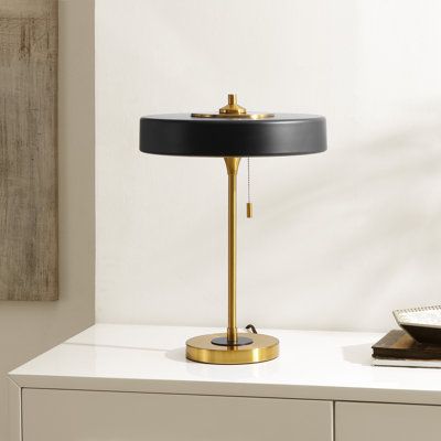 Bring a dose of sophistication to your tabletop with our Decker table lamp. Featuring a refined silhouette and well-defined proportions, our table lamp impresses with its effortless charm. A slim metallic drum shade and slender stem lend a sleek and modern presence to the lamp. It features a contrasting brass and white metallic finish to serve as a sophisticated and luxe addition to any tabletop. Finished off with a pull chain, our table lamp offers a focused pool of light to beautifully complem Brass Bedside Lamp, Glass Globe Pendant Lights, Bar Lighting Design, Table Lamps Design, Hollywood Bedroom, Modern Table Lamp Design, Bedroom Pieces, Bar Lamp, Industrial Pendant Lamps