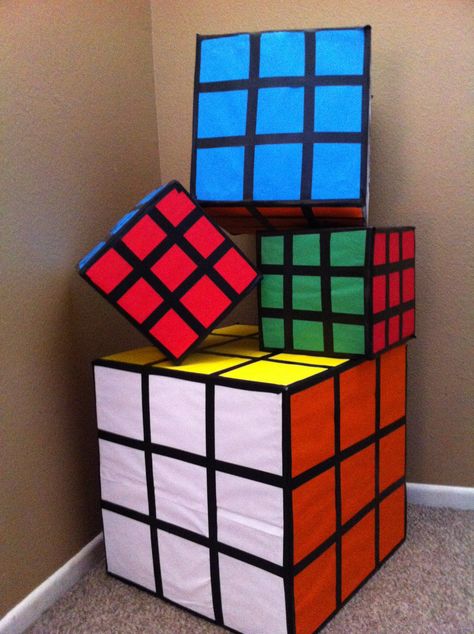 First time making these Rubix cubes for a 80's party . The mid size one is to hold the  "gift cards" easy and fun to make ! Use various sizes of  square boxes , black electrical tape and color scrapbook paper . I glued all the papers down then used the tape all around. Easy and guest will love how they look!!! Decades Party, Decade Party, 80s Party Decorations, 80s Birthday Parties, 1980s Party, 90s Theme Party, 80s Decor, 80s Theme Party, Rubix Cube