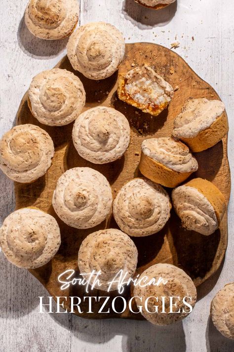 Hertzoggies on a wooden board on a white background. Apricot Jam Cookies, Coconut Tartlets, Coconut Meringue, Cape Malay, Meringue Topping, Bunny Chow, Milk Tart, Mini Tart Pans, Baking Recipes Cookies