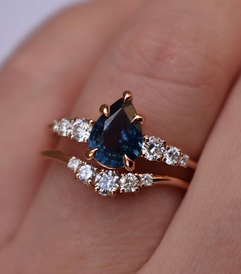 Charming teal blue sapphire engagement ring set radiates beauty from every angle. An exquisite central pear shaped teal sapphire is enchanted by lustrous diamonds. The dazzling array of gems are meticulously encased in a rose gold base for a classically feminine feel. This unique engagement ring set combines an old world elegance with modern glamour. Just perfect for brides, seeking a ring that truly stands out from the crowd. Sapphire Engagement Ring Set Details: Central Stone: Natural teal blu Sapphire Engagement Ring Pear, Pear Sapphire Ring, Unique Engagement Rings Sapphire, Sapphire Wedding Ring Set, Blue Green Sapphire Ring, Rings Sapphire, Sapphire Engagement Ring Set, Blue Sapphire Engagement Ring, Blue Engagement Ring