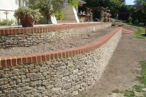 Stone/brick retaining walls - raked out joints so no mortar showing. Brick cap Drain Landscaping, Flint Garden, Retention Wall, Brick Retaining Wall, Stucco Wall, Landscaping Pool, Garden Retaining Wall, Garden Walls, Stone Retaining Wall