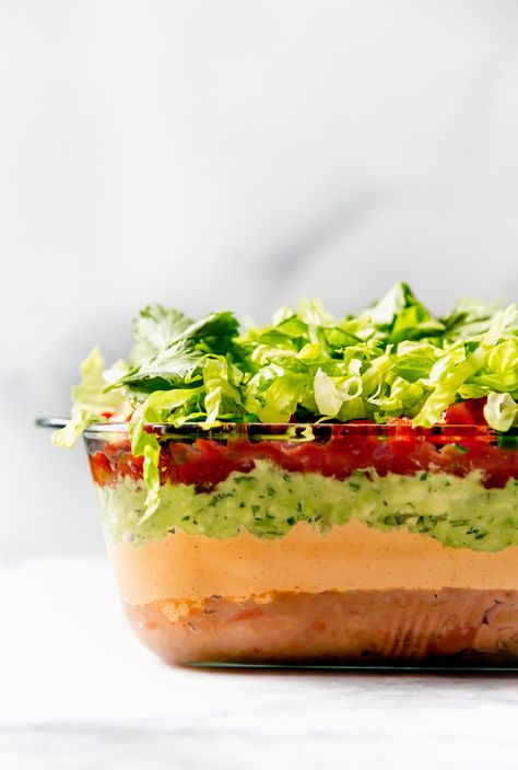 deep dish vegan 7-layer dip recipe - you've got to try this modern + fresh vegan 7-layer dip recipe made with 2 major twists! NO weird ingredients + TONS of flavor. plant-based, vegan, HEALTHY! #playswellwithbutter #vegan #plantbased #7layerdip Mexican Dip Recipes, 7 Layer Dip Recipe, Seasoned Sour Cream, Vegetarian Dip, Layered Dip Recipes, Layered Bean Dip, Layered Taco Dip, Seven Layer Dip, Appetizers For A Crowd