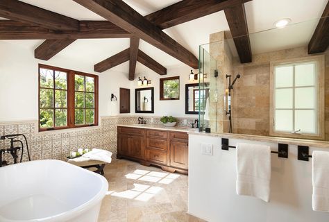 Spanish Mediterranean master bathroom interior design in Santa Barbara. Wood beams, hand painted wall tile wainscotting, limestone shower and floors, soaking tug | Santa Barbara Mediterranean Bathroom Ceiling Ideas, Wooden Ceiling Beams, Spanish Mediterranean Homes, Timeless Home Decor, Santa Barbara Style, Stone Vanity, Bronze Fixtures, Spanish Mediterranean, Mediterranean Interior