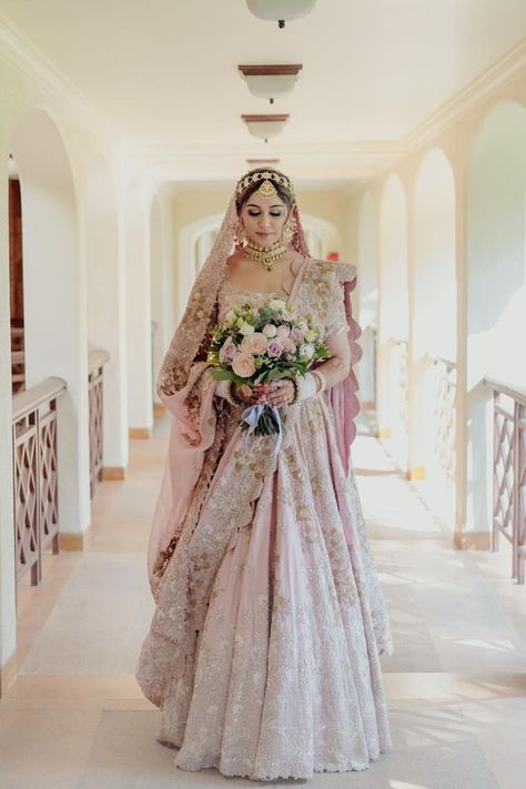 Bride in a pastel pink lehenga with a bouquet Pastel Bridal Lehenga, Blush Pink Lehenga, Pink Bridal Lehenga, Pastel Pink Weddings, Goa Wedding, Indian Bride Outfits, Anamika Khanna, Anita Dongre, Pink Lehenga