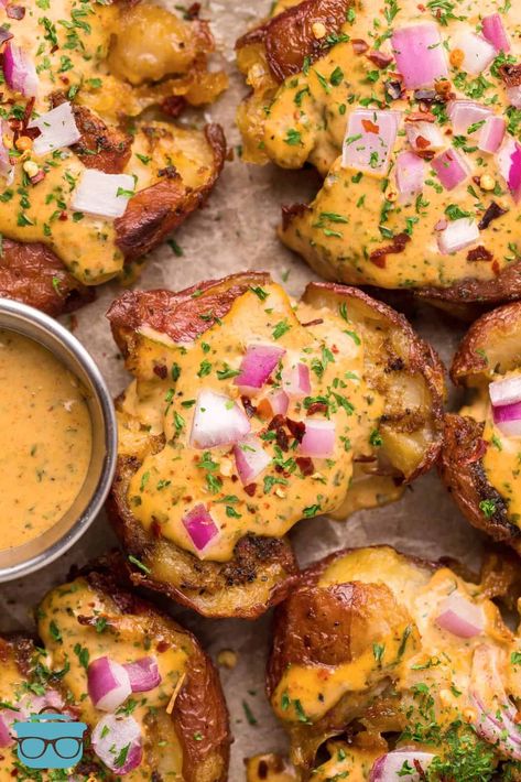 Overhead of Smoked Cajun Smashed Potatoes on parchment paper with sauce on side. Creamy Cajun Sauce, Smashed Red Potatoes, Cajun Potatoes, Smoked Potatoes, Traeger Grill Recipes, Cajun Sauce, Crushed Potatoes, Potatoes Recipes, Smoked Food