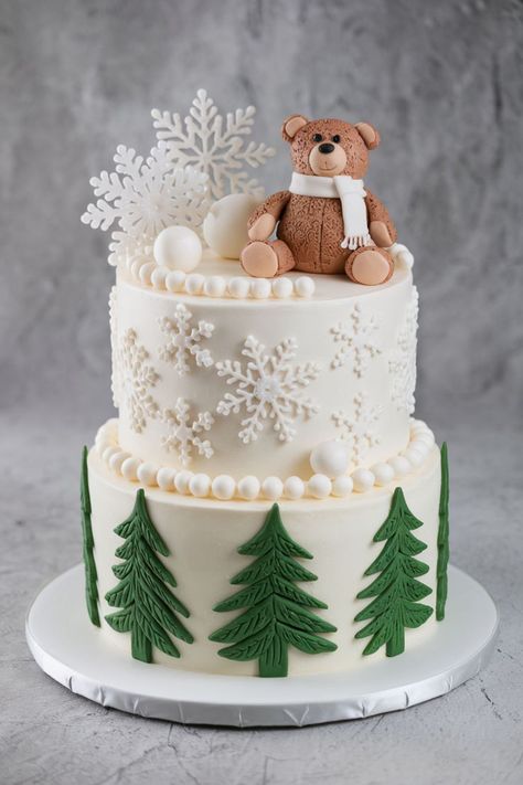 A snowy woodland-themed baby shower cake featuring a teddy bear topper, snowflake decorations, and pine tree accents, one of over 25 ideas for a February baby boy shower. Baby It's Cold Outside Baby Shower Cake, It’s Cold Outside Baby Shower Cake, February Baby Shower Ideas, Teddy Bear Topper, Winter Baby Shower Cake, February Baby Shower Themes, February Baby Showers, Boy Baby Shower Food, February Baby