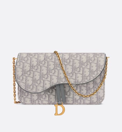 The saddle pouch with chain is a modern and practical creation with smooth and harmonious lines. Crafted in gray dior oblique jacquard, it features an asymmetric flap and an antique gold-finish metal d stirrup. The spacious interior will accommodate any essentials, while the chain allows it to be worn over the shoulder or crossbody. The pouch can be ideally paired with other saddle creations. The characteristics: flap closure   front d stirrup   one compartment   six card slots   one patch pocke Gris Dior, Saddle Pouch, Dior Purse, Luxury Outfit, Dior Shoulder Bag, Dior Collection, Dior Oblique, Girly Bags, Christian Dior Couture