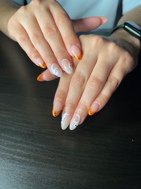 Ghost accents with an orange french tip and black stars Short Almond Halloween Acrylic Nails, Orange French Tip Halloween Nails, Orange Halloween Nails Acrylic, White And Orange Nails Acrylic, Ghost French Tips, Halloween Ghost Nails, Orange French Tip, Reverse French Nails, Ghost Nails