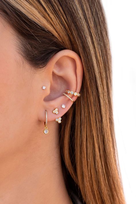 The Bergen are cubic zirconia huggie hoop earrings with a dangling bezel cubic zirconia charm. These dainty, modern, minimalist-style earrings can be worn daily as well as on special occasions. Perfect for a gift! Features: * Inner diameter: 9 mm. * Outer diameter: 12 mm.  * Charm size: 4 mm.  * They are sold in singles and pairs. Both options are available on the dropdown menu. * All of our jewelry is made of sterling silver (925 mm), and our gold jewelry is gold plated in 18K gold. Nickel free Couch Ear Piercing, Ear Piercing Ideas Orbital, Savannah Guthrie Ear Piercing, Outer Conch Piercing Hoop, Curated Ear Piercing Ideas Classy, Bohemian Piercings, Conch Piercing Ideas, Conch Hoop Piercing, Double Conch Piercing