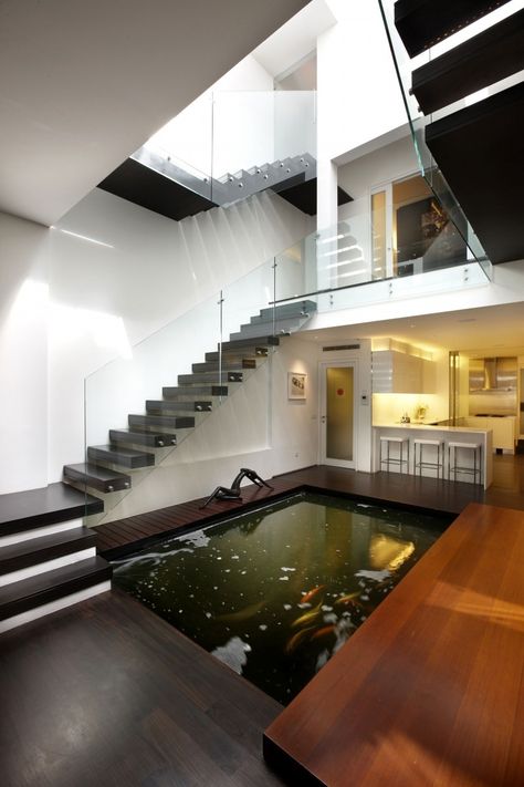 Koi fish pond inside house. Cool idea, but  it seems like the maintenance for it would be  increased if it was indoors. Indoor Pond, Koi Pond Design, Kolam Koi, Escalier Design, Luxury Modern Homes, Pond Design, 아파트 인테리어, Patio Interior, Indoor Swimming