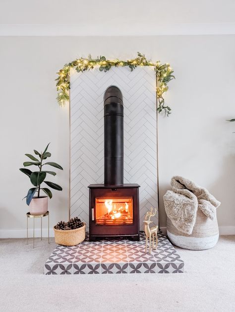 How to create a surround for a wood stove burner with no chimney. Living room flat wall made to look like the stove has always belonged Tile Behind Wood Burning Stove, Herringbone Tile Wall, Tiled Hearth, Stove Surround, Wood Stove Surround, Wall In Living Room, Wood Burner Stove, Stove Ideas, 60s House