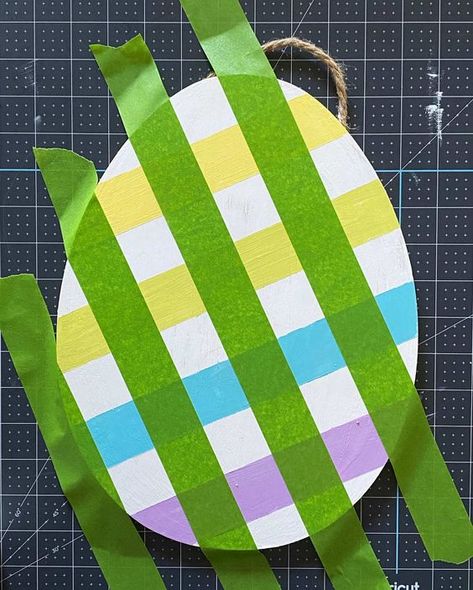 How to paint multicolored plaid or buffalo check plaid using painters tape and paint. DIY plaid Easter egg door hanging. Buffalo Plaid Door Hanger Diy, How To Paint Plaid Pattern Buffalo Check, Plaid Painting Diy, Easter Egg Door Hanger Wood, Wooden Egg Decorating Ideas, Easter Egg Wood Crafts, Painted Wood Easter Eggs, Painting Buffalo Plaid Diy, Painted Wooden Eggs Easter Ideas