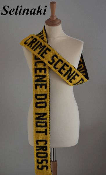 A yellow scarf in the style of a police crime scene tape with black block letters, saying crime scene do not enter