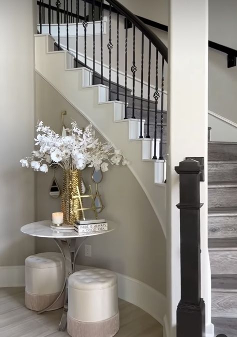 Curved Stairwell Decor, Small Space By Stairs Decor, Decor By Staircase, Curved Stair Wall Decor, Corner Of Stairs Decor, Curved Staircase Accent Wall, Stairwell Decorating Ideas, Curved Staircase Foyer Entryway Modern, Curved Staircase Foyer Entryway