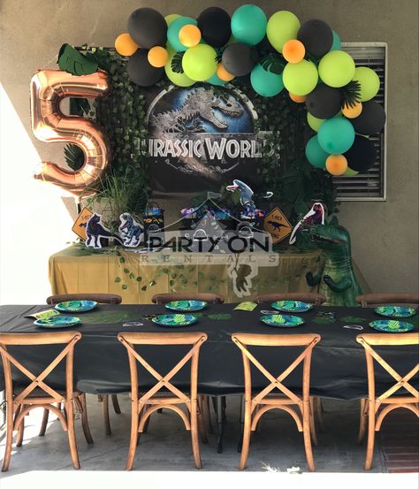 Jurassic world birthday party set up ideas with wood cross back chairs kids table decor with green black orange balloon garland dinosaur trex t-rex birthday decor. Dinosaur Party Set Up, Jurassic Park Party Table Decorations, Simple Dinosaur Birthday Party Decorations, Jurassic Birthday Party Ideas, Jurassic World Balloon Garland, Dinosaur Table Decor, T Rex Party Ideas, Trex Party Ideas, Jurrasic World Birthday Party Ideas Diy