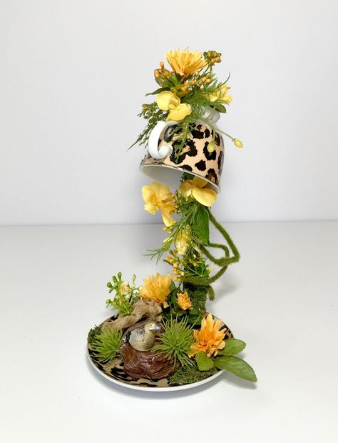 "Floating Tea Cup Saucer Ceramic Floral Arrangement, Novelty Flowers Arrangement Centerpiece, Unique Flower Table Decoration, Leopard Print Tea Cup & Saucer, Gift Check out this stunning, unique small centerpiece! Up for sale is a magical, floating, suspended tea cup. This leopard print tea cup is magical suspended in a Woodland scene with driftwood, brown rocks, yellow flowers, faux greenery & a resting duck. What a fun conversation piece! Would make a great gift for that special occasion. All Blue Flower Centerpieces, Tea Cup Centerpieces, Floating Tea Cup, Flower Table Decorations, Greenery Arrangements, Small Centerpieces, Floral Bowls, Printed Cups, Artificial Flower Arrangements