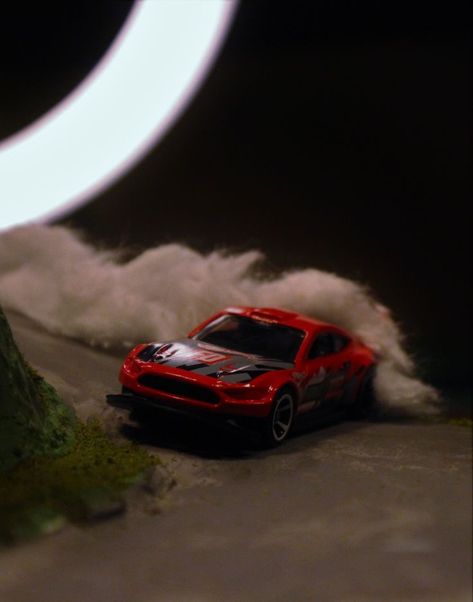 A hot wheel drifting on a mountain road photo. A Mustang drifting. Hot Wheels Photography, Baby Neck Float, Music Photoshoot, Micro Photography, Toy Photography, Hot Wheel, Sculpture Ideas, Car Stuff, Toys Photography