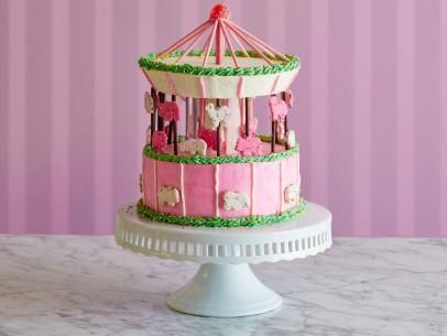 Frosted Animal Cracker Carousel Cake Recipe | Food Network Kitchen | Food Network Pastel Carousel, Biscuit Sticks, Decorative Desserts, Frosted Animal Crackers, Kid Cakes, Rotating Cake Stand, Animal Cracker, Dreamy Desserts, 10 Inch Cake