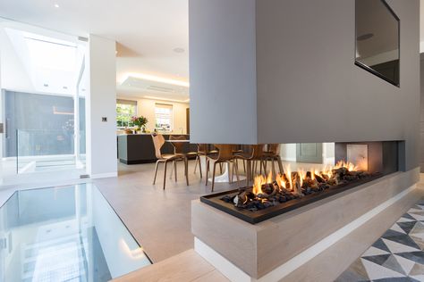 This stunning three sided gas fireplace forms part of a room divider. 2 Sided Fireplace Living Room Modern, Three Side Fireplace, Indoor Gas Fireplace Modern, 2 Sided Gas Fireplace, Three Way Fireplace, Fire Room Divider, Three Sided Fireplace Ideas Modern, Room Divider Fireplace, Three Sided Fireplace Ideas