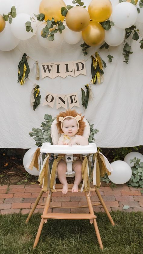 Adorable "Wild One" first birthday setup with a baby dressed as a lion, rustic balloon garland in gold and white, and leafy greenery for a playful, nature-inspired theme. Lion Birthday Theme, Birthday Themes For Girls, Baby Lion Costume, Party Ideas For Girls, First Birthday Party Ideas, Wild One Party, Lion Birthday, Earthy Decor, Leo Birthday