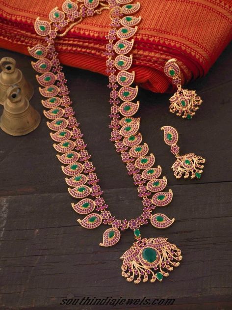 This imitation ruby emerald haram set is made of mango shaped motifs, each studded with tiny rubies and oval shaped emeralds. Kempula Haram Designs, Mango Haram, Mango Mala, Haram Designs, Indian Bridal Jewellery, Traditional Indian Jewellery, Long Pearl Necklaces, South Indian Jewelry, Pearl Jewelry Necklace