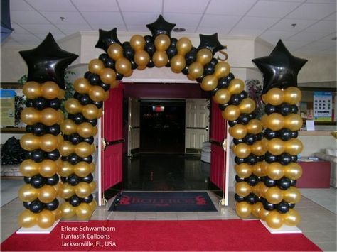 These balloon columns and arch will make a grand entrance piece.   These balloons are not my work, but you can call It's Party Time at 618-651-1505 in Highland, IL if interested in balloon decor like this picture. Grammy Decorations, Prom Balloon Arch, Hollywood Balloons, Award Ceremony Decorations, Black And Gold Balloon Arch, Uk Graduation, Event Entrance Design, Prom Balloons, Balloon Archway