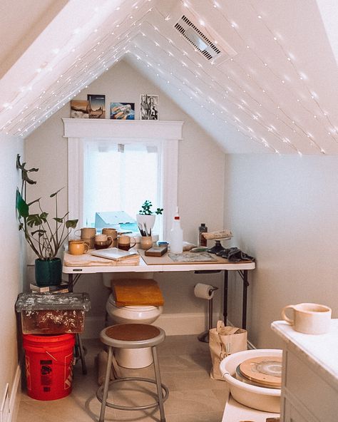 A cozy pottery studio set up in a small bathroom with sparkle lights and a pottery wheel, table, and window. Pottery Studio Aesthetic Living Room, Home Pottery Studio Workspaces, Small Pottery Studio At Home, Pottery Studio Aesthetic Home, Small Home Pottery Studio, At Home Ceramic Studio, Small Home Ceramic Studio, Home Pottery Studio Setup, At Home Pottery Studio