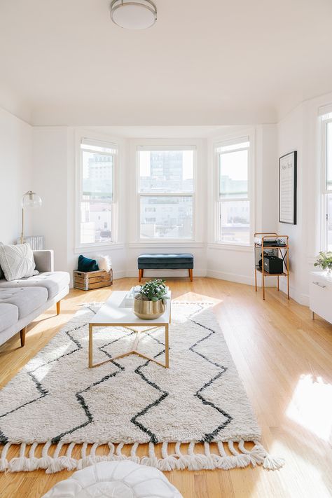 neutral living room inspo | muted rug | coffee table styling | bright living room | light wood floors | #theeverygirl Apartment Wood Floors, Living Room Decor Wood Floor, Rugs For Light Wood Floors Living Room, Light Filled Living Room, Rug For Light Wood Floor, Living Room White Walls Wooden Floor, Living Room Designs Wood Floors, Yellow Wood Floors Living Rooms, Living Room Light Floors