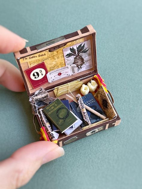 A miniature wizard's suitcase, scale 1:12, for a dollhouse. The set includes a suitcase decorated with stickers, books with spells, a magic wand, candles, a scarf and other magical decor. Each item is handmade, the set will be a great gift and decoration for a dollhouse, create the right mood. All items are fixed with glue Harry Potter Suitcase, Miniature Harry Potter, Mini Treasure Chest, Diy Doll Suitcase, Miniature Gifts, Doll Suitcase, General Gift Ideas, Matchbox Crafts, Magical Decor