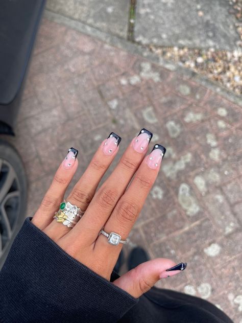 Black french tip nails with gemstones, also wearing silver rings Black French With Gems, Black Nails With Silver French Tip, Black Tip With Silver Line Nails, Black French Tip Silver Glitter, Black French Tips With Silver Line, French Tips Silver, Nails With Gemstones, Black French Tip Nails Silver Lining, French Tip Nails With Gems