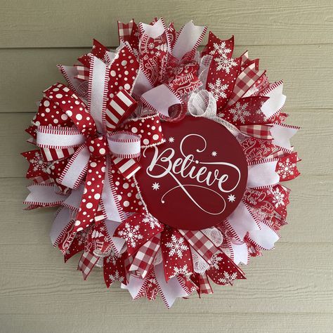 "Believe in the Magic...Red and White come together creating this modern Merry Christmas holiday wreath. This full sized wreath measures 26 inches in diameter and 9 inches deep. Created on a bed of red and white fabric mesh, this design features a 10\" round birch wood sign painted in scarlet red with the word \"Believe\" in crisp white script vinyl lettering. Coordinating red and white premium wired ribbon streamers surround the sign creating a modern Christmas feel. Dimensions height: 26\" x w Noel Wood Sign, Red And White Christmas Wreath Ideas, Red And White Christmas Wreaths, Ideas For Christmas Wreaths, Whimsical Christmas Wreath, Ribbon Wreath Tutorial Step By Step, Diy Wreaths For Front Door, Red Mesh Wreath, Mesh Christmas Wreaths