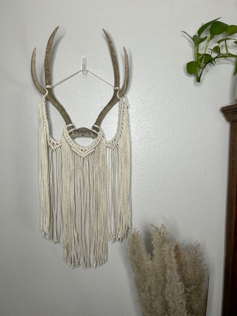 Add the perfect touch to your boho home decor with this deer antler macramé wall decor. It measures approx 11” wide by 30” long. It will look great in your living room, bedroom or office. #macramewallhanging #macrameantler #antlermacrame #antlerwalldecor #antlermount #bohoantlerdecor #rusticfarmhousedecor Hanging Deer Antlers, Antler Macrame, Antler Wall Hanging, Rustic Farmhouse Wall Decor, Antler Wall Decor, Antler Mount, Elk Horn, Antler Wall, Macrame Home Decor