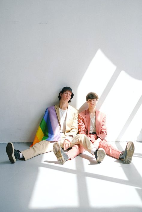 Two Men Sitting on the Floor with a Gay Pride Flag · Free Stock Photo Sitting On The Floor Pose Drawing, Pride Month Photography, Pride Flag Poses, Queer Photoshoot Ideas, Holding Pride Flag Pose Reference, Sitting On The Floor Reference, Sitting On The Floor Pose Reference, Floor Photoshoot Ideas, Pose Reference Sitting On Floor