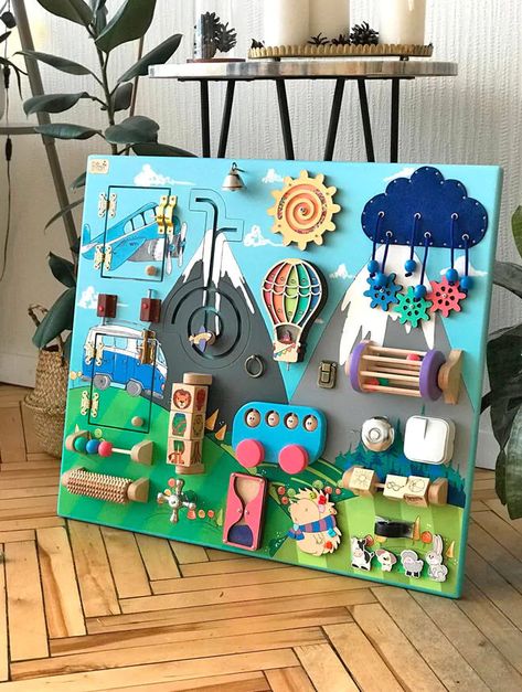 21 toddler busy boards for fine-tuning motor skills | Mum's Grapevine Wall Mounted Busy Board, Montessori Board Diy, Handmade Busy Board, Activity Wall For Toddlers, Diy Sensory Boards, Baby Zintuiglijk, Perlengkapan Bayi Diy, Baby Activity Board, Montessori Board