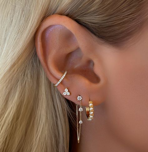 Tips For Curating the Perfect Dainty Feminine Ear Stack: There’s something magical about a well-curated ear stack—it’s like creating a miniature gallery on your ear. 1. Start with the Stud The foundation of any great ear stack is a chic and understated stud. Opt for something that speaks to your personal style—whether it’s a tiny diamond, a pearl, or a delicate gold ball. This piece anchors the look, adding a subtle sparkle that doesn’t overpower the rest of the stack. 2. Add a Huggie for... White Gold Earring Stack, 3 Peircings Earring Stack, Ear Design Piercing, Dainty Earring Stack, Ear Mapping, Miniature Gallery, Earring Huggies, Ear Piercing Combinations, Ear Stacking